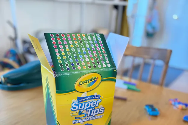 Owner-used Crayola Super Tips 100-count marker box open on a family art table