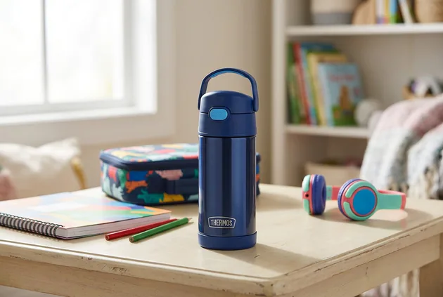 Four preschool water bottles beside a lunchbox, backpack, bottle brush, and straw parts